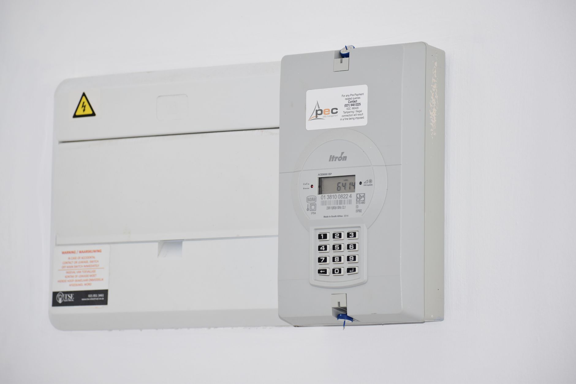 Compteur électrique et tableau fixés sur un mur blanc