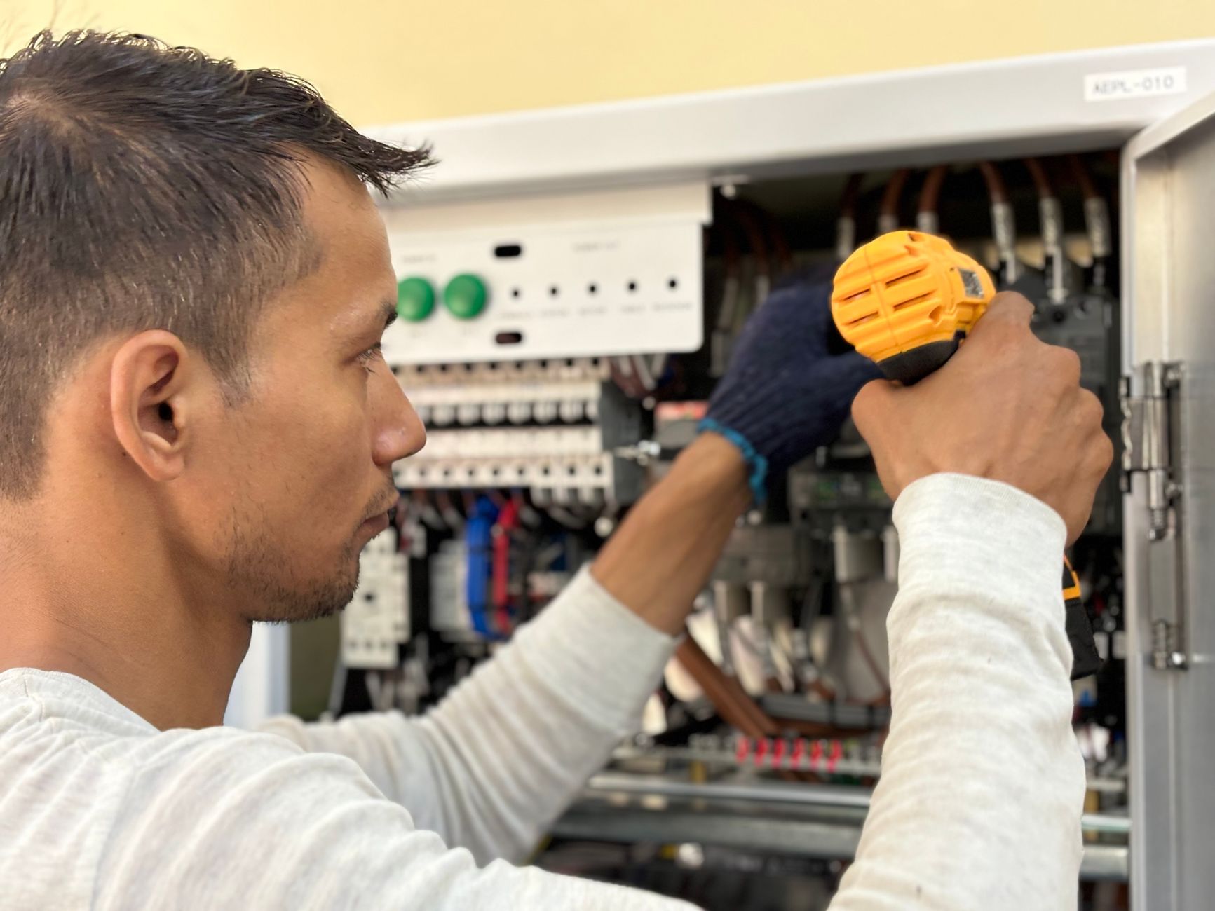Technicien au travail sur un tableau électrique ouvert