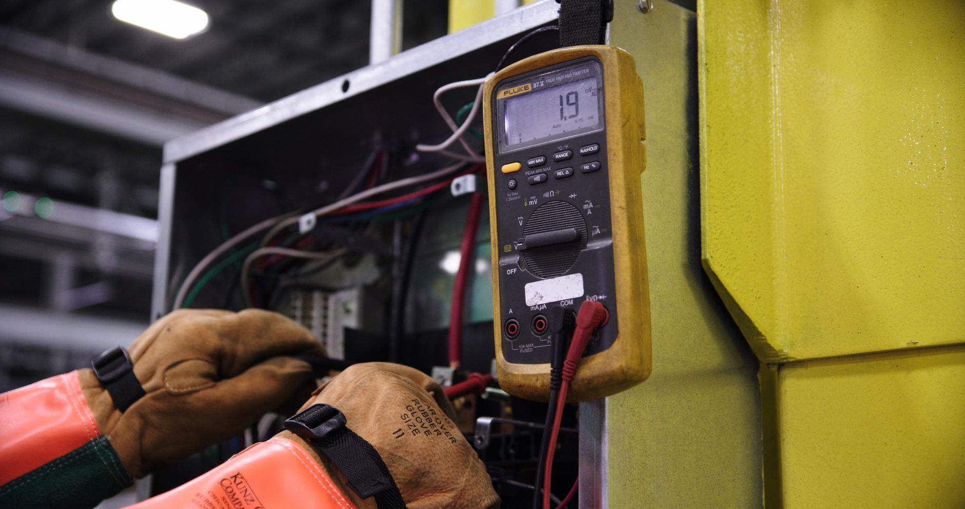 Électricien testant un circuit avec un multimètre
